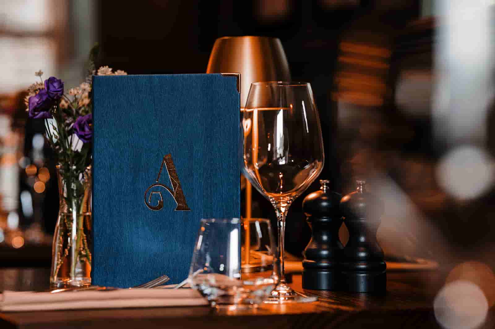 A table at The Ashford Arms showing a menu, wine glasses and table decorations.